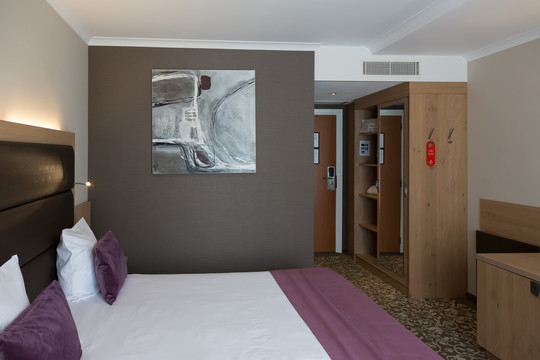 Chambre supérieure avec lit double, mettant en avant les équipements modernes et la literie confortable.