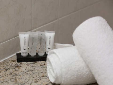 Produits de douche offerts dans la salle de bain privative de la chambre supérieure avec lit double.