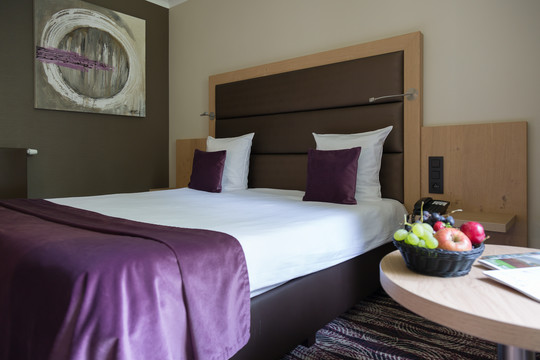 Photo du lit double confortable et moderne dans la chambre économique de l’hôtel Van der Valk à Nivelles, offrant un cadre cosy pour un séjour reposant.