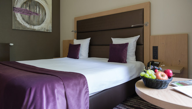 Lit double confortable dans la chambre économique de l’hôtel Van der Valk Nivelles