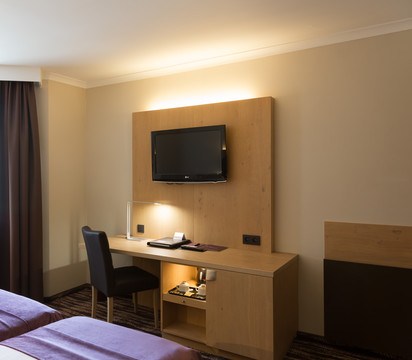 Espace de travail équipé avec bureau et chaise dans la chambre économique avec lits jumeaux de l’hôtel Van der Valk Nivelles.
