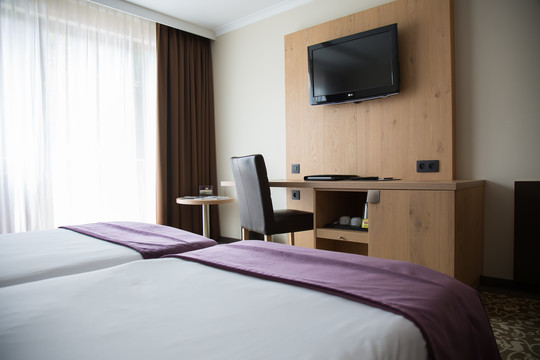 Espace de travail équipé avec bureau et chaise dans la chambre supérieure avec lits jumeaux à l’hôtel Van der Valk Nivelles.