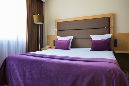 Lit double de la chambre supérieure familiale à l’hôtel Nivelles-Sud, offrant confort et détente pour les parents lors d’un séjour en Brabant Wallon.