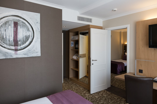 Chambre familiale supérieure au Van der Valk Hotel Nivelles-Sud, avec literie confortable et décoration moderne pour un séjour en famille réussi.